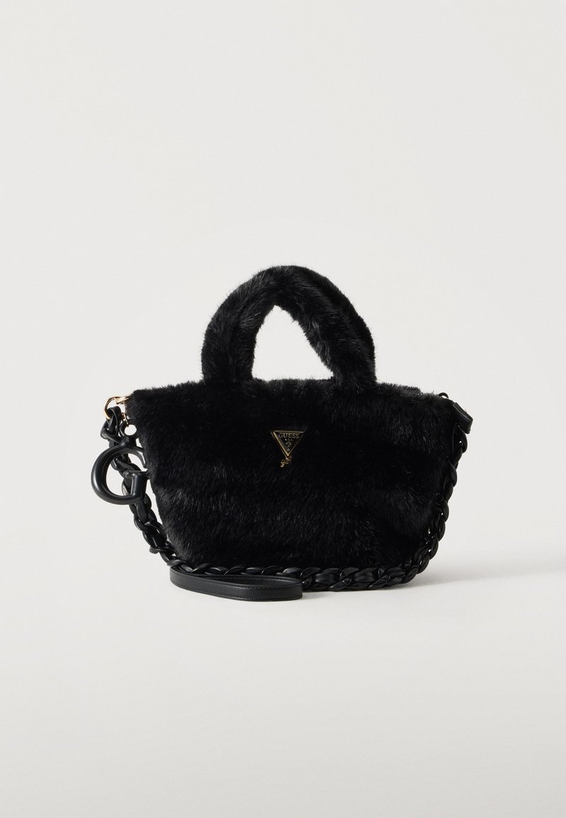 Sac à main en fausse fourrure noire avec des poignées courtes, une bandoulière torsadée et un petit logo GUESS doré en forme de triangle à l'avant.