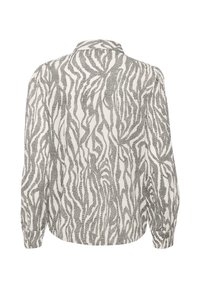 Dlhý rukáv blúzka s čiernobielym abstraktným zebrovým vzorom, so zapínaním na gombíky na koncoch rukávov a malým golierom, predvedená zozadu.