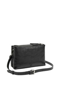 Czarna skórzana torba na ramię o gładkiej fakturze, z zapięciem na zamek błyskawiczny i regulowanym paskiem. Charakteryzuje się minimalistycznym designem i srebrnymi akcentami.