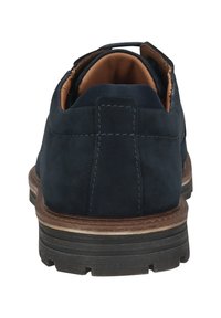 Chaussure en daim bleu marine avec un bout arrondi et doublure en cuir marron. Présente des coutures contrastantes et une semelle en caoutchouc noir texturé.