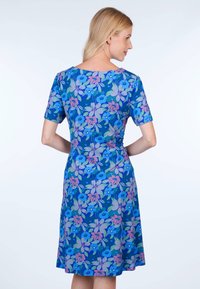 Blumen Kleid in Blau, mit kurzen Ärmeln und lockerer Passform. Lebhaftes Blumenmuster in Pink- und Lilatönen mit grünen Akzenten.