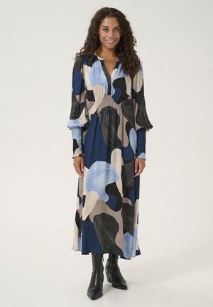 Long, flowy dress in blue, black, and beige abstract patterns; soft fabric, V-neck, balloon sleeves, and gathered waist detail.