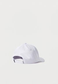 Λευκό καπέλο μπέιζμπολ εμφανιζόμενο από πίσω με ρυθμιζόμενο λουρί και οπές αερισμού σε λευκό απλό φόντο.