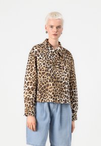 Jakna s uzorkom leoparda, s ovratnikom, dva prednja džepa i opuštenim krojem; izrađena od mekanog materijala s glatkom teksturom.