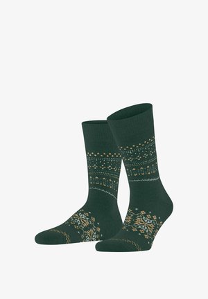 Dunkelgrüne Knöchelsocken mit beigen und hellgrauen geometrischen und Schneeflockenmuster am Bündchen, Schaft und Fuß.