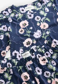 Haut à manches longues bleu marine à motifs floraux et pantalon à taille élastique avec motif de fleurs roses et lavande et feuilles vertes.