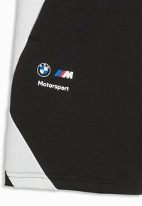 Panneau de tissu noir avec une bande diagonale blanche présentant le logo BMW, le logo tricolore BMW M, et le mot "Motorsport" en texte blanc.