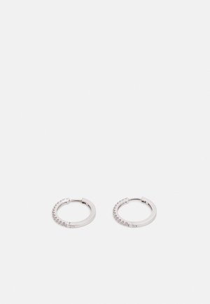 Boucles d'oreilles en argent en forme de anneau, dotées d'une finition lisse et polie, avec une rangée de petites pierres transparentes incrustées le long d'un bord.