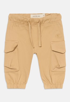 Beežid väikelapse cargo-püksid elastse vöökoha ja mansettidega, paelaga, küljetaskute kattega ja väike Calvin Kleini logo paremal reiel.