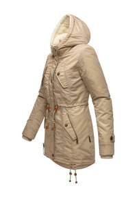 Beige parka jacket with a hood, quilted texture, side pockets, drawstring waist, and knit cuffs. Lined with soft material, featuring wooden accents.