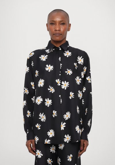 Chemise noire à boutons avec un motif floral de marguerites blanches. Manches longues, col et texture lisse. Fermeture à boutons sur le devant et coupe ample.