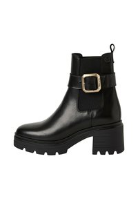 Zwarte leren enkelboot met een chunky hak, elastische zijpaneel en een metalen gespaccent. Gladde textuur en robuust zoolontwerp.