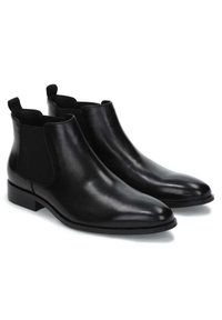 Botas Chelsea de cuero negro con punta redondeada, paneles laterales elásticos y tiradores en el tobillo; textura elegante y suave.