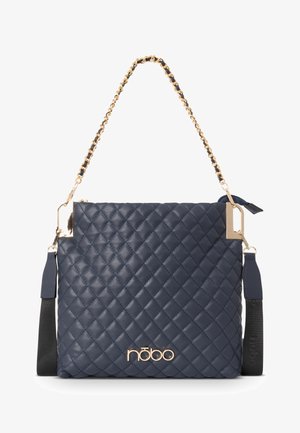 Quilted navy handbag with gold hardware and chain strap. Features a sleek rectangular shape and logo detail at the bottom. Textured surface.