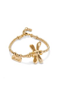 Bracelet en métal doré avec un design en perles, accentué par un nœud central et une étiquette gravée du mot "Suerte". Fermeture réglable.