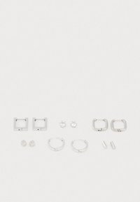 Ensemble de bijoux en argent comprenant des boucles d'oreilles carrées, des créoles rondes, des clous cubiques et deux paires de clips, tous avec une finition métallique lisse.