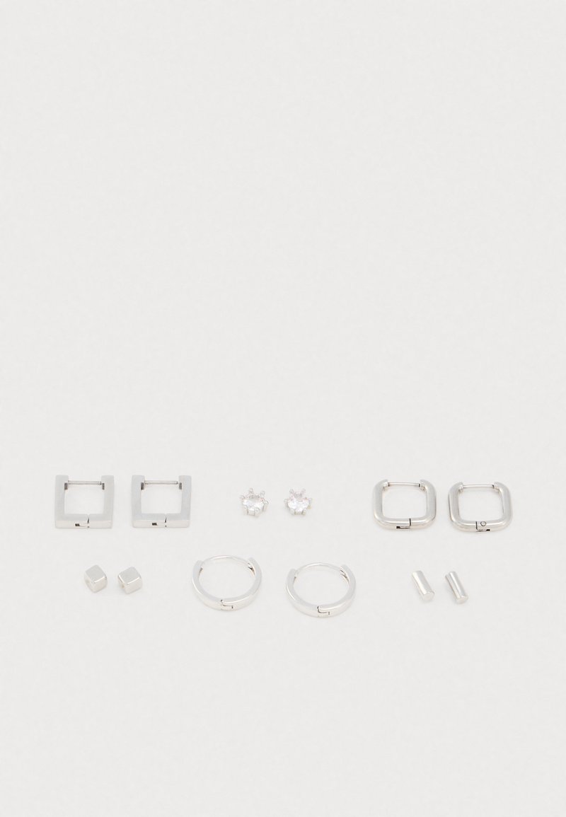 Ensemble de bijoux en argent comprenant des boucles d'oreilles carrées, des créoles rondes, des clous cubiques et deux paires de clips, tous avec une finition métallique lisse.