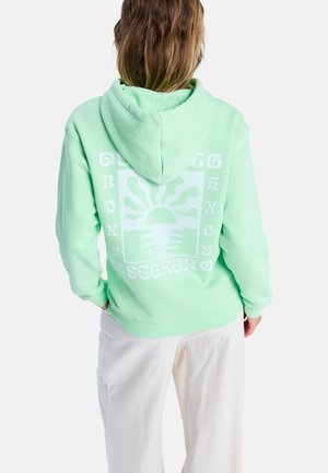 Mint green hoodie with a drawstring hood. Features a white graphic design on the back, depicting a sun and hands, with text "SEEKER."