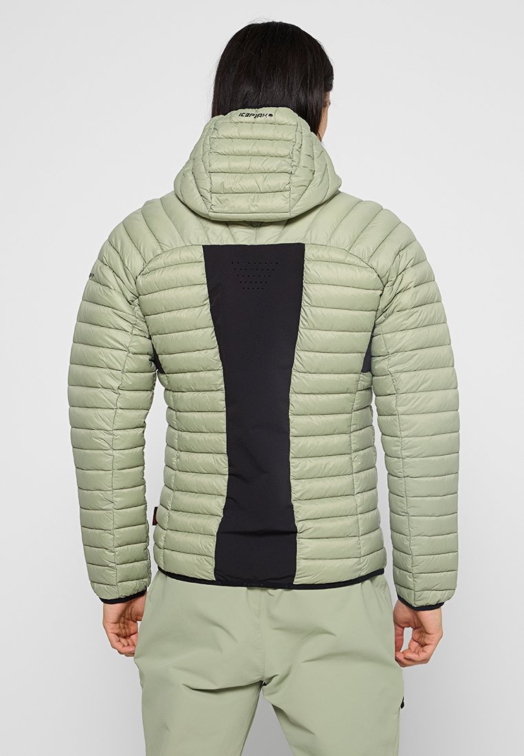 Lichtgroene pufferjack met een zwarte rugpaneel, gekwietste textuur, verstelbare capuchon en logo-accenten op de kraag en mouwen.