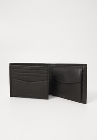 Portefeuille en cuir noir avec plusieurs emplacements pour cartes, une poche plate et des détails de couture. L'intérieur présente une finition texturée.