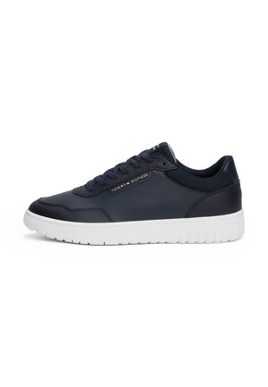 Czarny niski sneaker z białą podeszwą, sznurowany z przodu, z logo Tommy Hilfiger po boku i na języku.