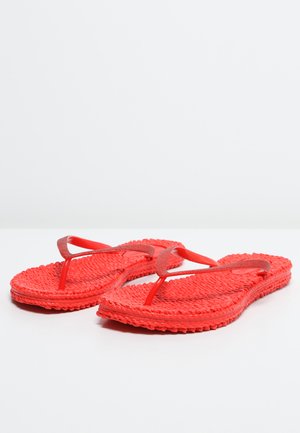 Paar leuchtend roter, strukturierter Flip-Flops mit dünnen Riemen, nebeneinander auf einer schlichten weißen Oberfläche präsentiert.