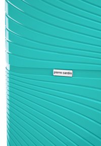 Valigia in polipropilene color turchese con strisce diagonali testurizzate, dotata di una placca-logo argentata che riporta la scritta "pierre cardin." Finitura liscia.
