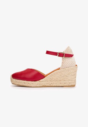 Sandalia de cuña de cuero rojo con puntera cerrada, plataforma de yute tejido, correa en el tobillo con hebilla dorada y contrafuerte del talón beige a cuadros.