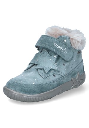 Samtgrüne Knöchelstiefel mit grauer Gummisohle, sternförmigen Akzenten und einem Kragen aus Kunstpelz. Klettverschluss oben für sicheren Halt. Silberne Sternmuster.