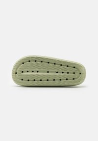 Talpa de pantof din cauciuc verde, de formă ovală, cu un model texturat în herringbone. Are orificii de ventilație și o margine netedă pentru confort.