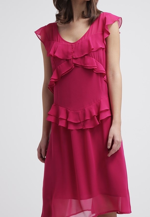 Vestido fucsia hecho de una tela ligera, con acentos de volantes en el corpiño y las mangas, con una silueta fluida y un dobladillo a la altura de las rodillas.