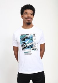 Bílý bavlněný tričko s grafickým potiskem v modré a černé, znázorňující text a umělecký design spojený s Vincentem van Gogh.