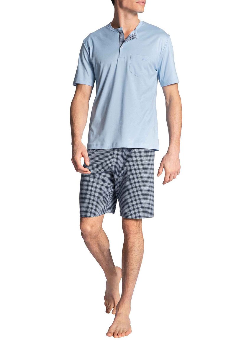 Lichtblauw kortmouwtopje met een zak en gestreepte blauwe shorts. De stof lijkt zacht te zijn, met een ontspannen pasvorm en comfortabel ontwerp.