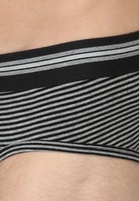 Schwarz-grau gestreifte Unterwäsche mit einer weichen Textur, versehen mit einem einfarbigen schwarzen Bund und einem dünnen grauen Streifen entlang der oberen Kante.