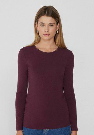 T-shirt à manches longues et col rond en bourgogne profond, fabriqué dans un tissu doux au toucher lisse. Dispose de manches ajustées et d'un design simple.