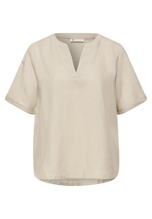 Blouse beige à manches courtes avec une fente en V au col et des manches retroussées, réalisée en tissu léger, avec une coupe ample et décontractée.