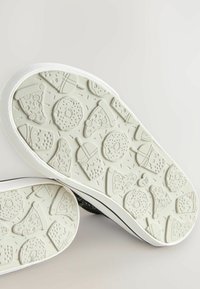 Rubberen sneakerzool met een textuurpatroon van pizza-slices, koekjes en drankjes. De kleur is lichtgrijs met een witte rand.