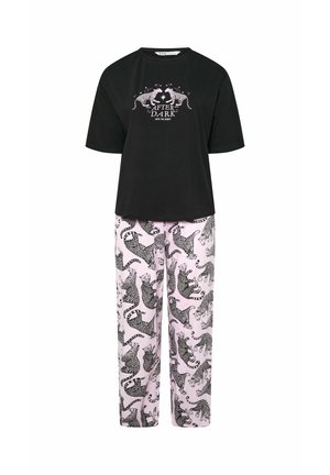 Zwarte top met korte mouwen met twee witte luipaarden en de tekst "After Dark", gecombineerd met lichtroze broek met zwarte luipaardprints.