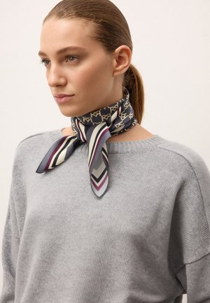Silketørklæde med et mønster i marineblå, beige og striber i bordeaux, grå og creme; bundet om halsen og komplementerer en grå sweater.