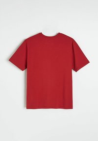 Czerwona koszulka z krótkim rękawem z okrągłym dekoltem, wykonana z miękkiej bawełny, o gładkim wzorze i standardowym prostym wykończeniu.