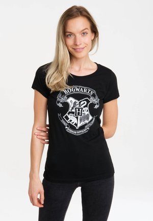 Black cotton t-shirt featuring a white Hogwarts crest graphic with intricate detailing. Classic fit with a round neckline and short sleeves.