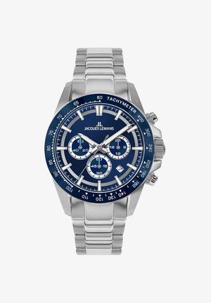 Nerūsējošā tērauda hronogrāfs ar tumši zilu ciparnīcu, sudraba akcentiem, tachimetra rāmīti un trim subciparnīcām laika funkcijām.