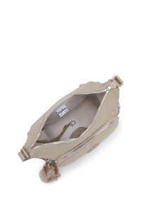 Beige texturerad väska med dragkedjestängning, utrustad med silverdetaljer, fodrad insida och en liten dekorativ pom-pom nyckelring.