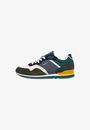 Sneakers with a white nylon upper, green and navy suede accents, a yellow heel detail, and a textured rubber sole. Casual athletic design.