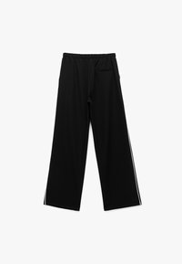 Pantalons de sport noirs avec un design à jambes larges, taille élastique et rayures blanches décoratives sur les côtés ; comprend une poche arrière.