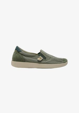 Zapato casual tipo slip-on de corte bajo en tejido verde oliva con suela de goma beige y pequeño detalle de botón cerca del panel lateral elástico.