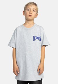 Harmaa lyhythihainen t-paita, joka on valmistettu puuvillasekoitteesta ja jossa on sininen "DC Shoes" -logo rinnassa; löysä istuvuus ja pyöreä kaula-aukko.