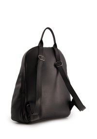 Sac à dos en cuir noir avec surface texturée, forme arrondie, poignée supérieure, bretelles réglables et design minimaliste.