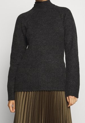 Pull en tricot côtelé gris foncé à manches longues associé à une jupe plissée vert olive, présenté de l'épaule jusqu'à mi-cuisse.