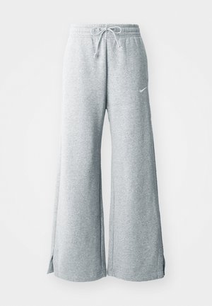 Heledad hallide püksid pehmest kangast, millel on nööriga vöökoht, laiad jalad ja külgsisselõiked. Nike logo on diskreetselt välja toodud.